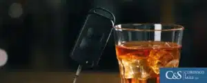 A glass of whiskey and a car key