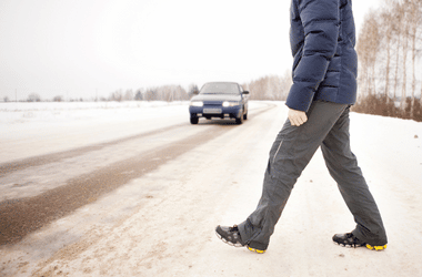 Pedestrian crossing road as vehicle looms in the distance - pedestrian accident lawyer