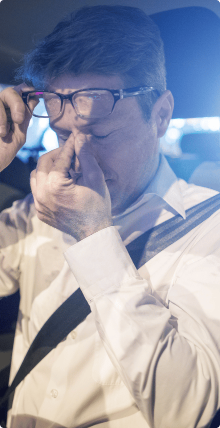 An image of a man wearing eyeglasses and closing his eyes while raising the eyeglasses with his right hand, which is resting on the bridge of his nose, in a gesture of contemplation or deep thought.