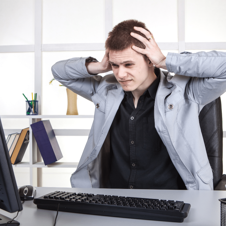 Man holding his head in the office because of a severe pain