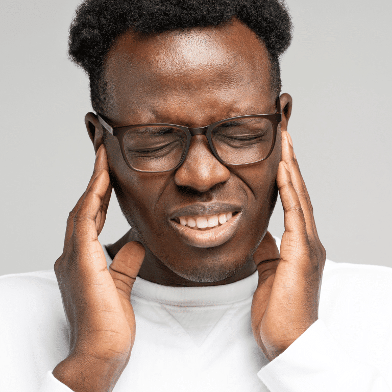 Man with severe head pain holding his chin