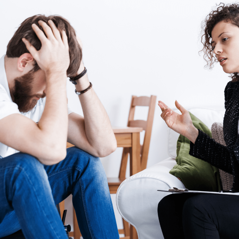 Man with severe head pain listening to a nurse