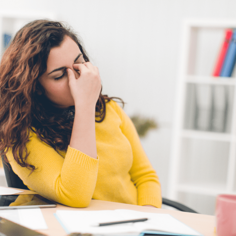 Woman holding her nose from head pain