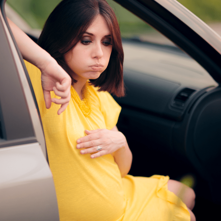 Pregnant woman sitting inside a car