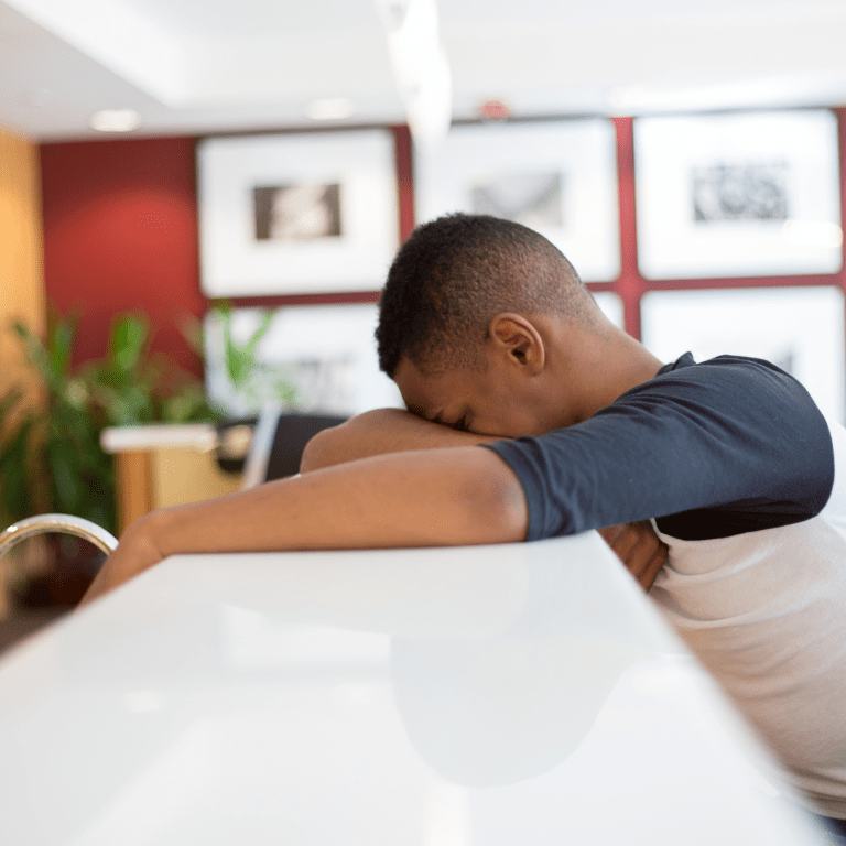 A man with headache at the bar facing down