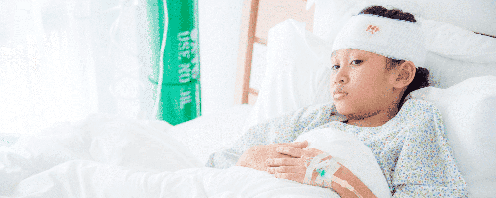 A young girl lying on a hospital bed with a head injury