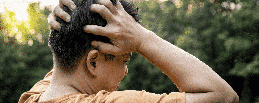 Man with post concussion syndrome holding his head