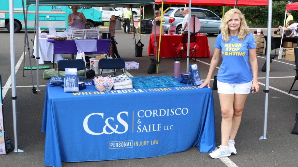 A woman standing beside the event table of the community unity national night out