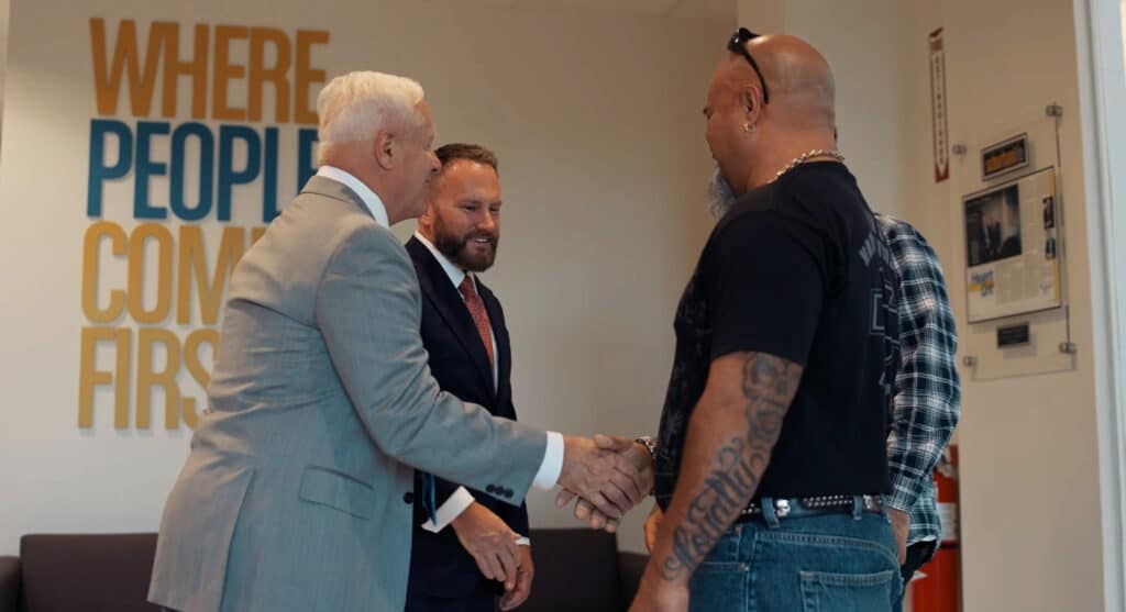 attorney John Cordisco shaking hands with happy clients