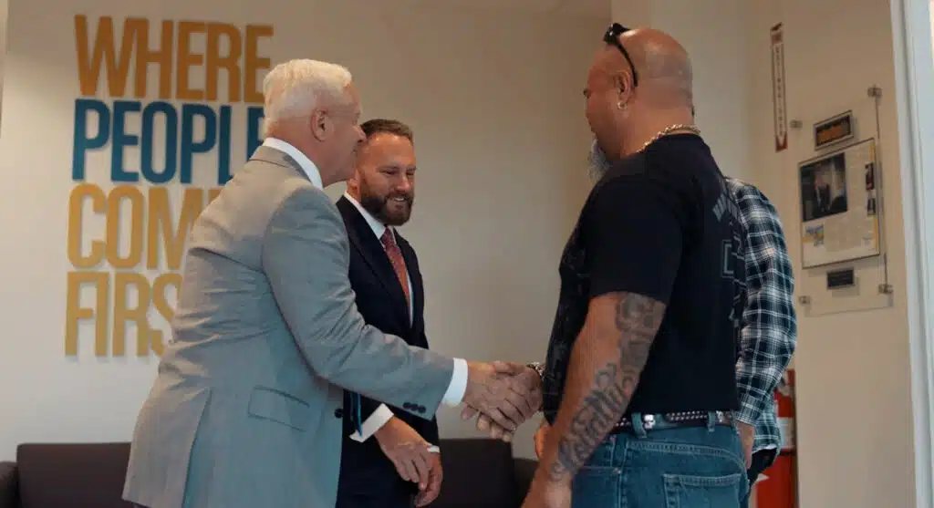 attorney John Cordisco shaking hands with happy clients