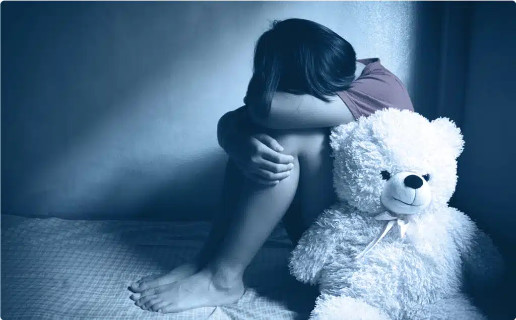 sad child huddled in corner