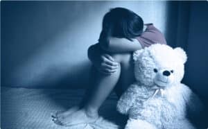 sad child huddled in corner