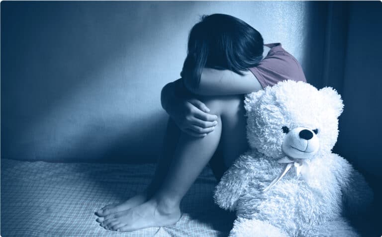 sad child huddled in corner