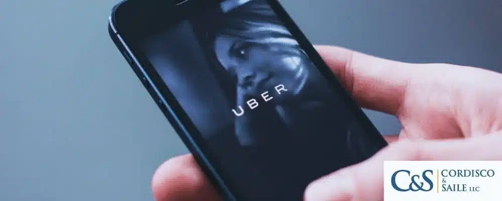 Person holding phone using uber ride-share app