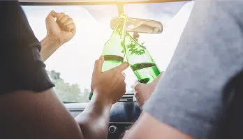 people clinking beer bottles together
