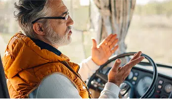 person talking while sitting at the wheel of car