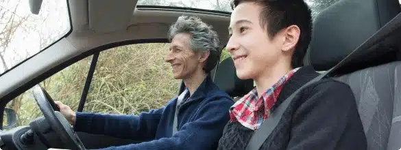 man and boy driving in car