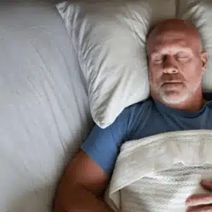 person lying down in bed with eyes closed