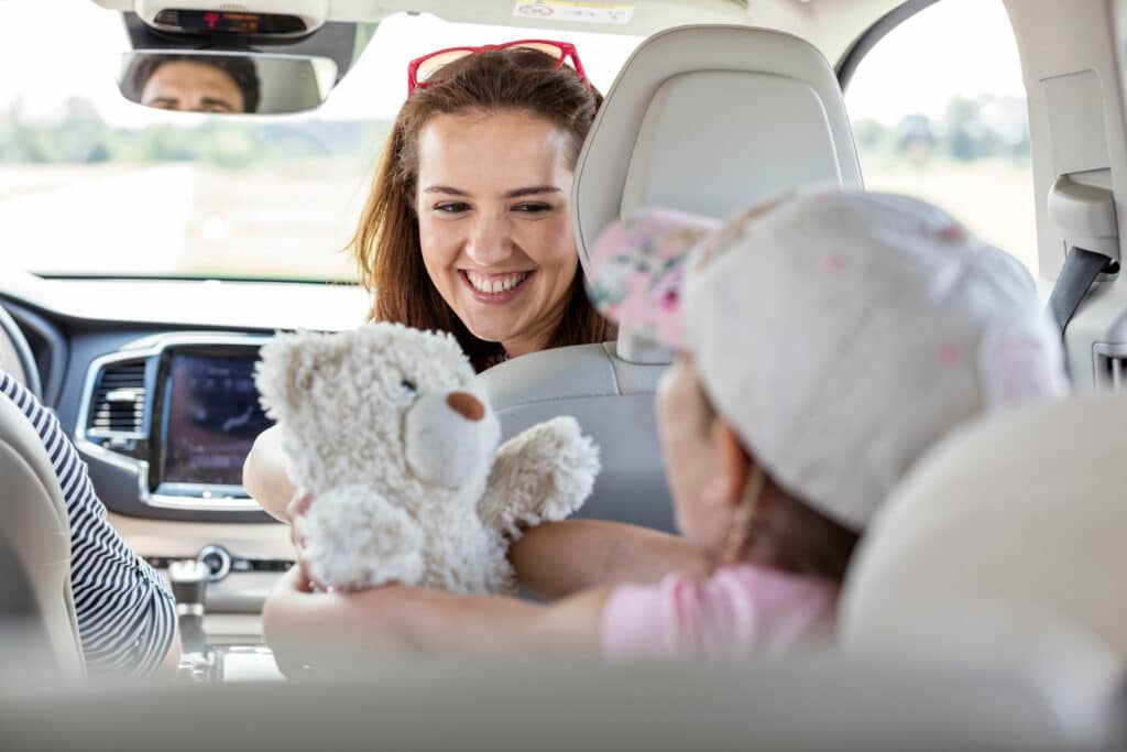 Mother giving her daughter a teddy bear