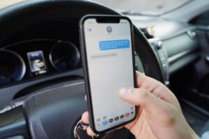 person busy texting on phone while driving